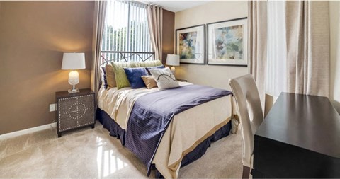 Spacious bedroom with plush carpeting and large window at Midora at Woodmont in Tamarac, FL